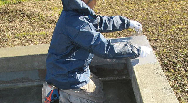 立上り部や床面に、防水材を塗布しながら、補強布を張っていきます