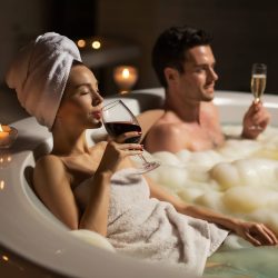 woman-towel-man-spa-tub-with-foam