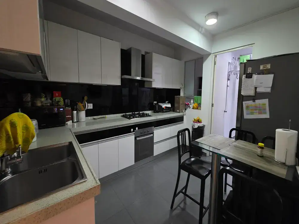 Modern kitchen with white cabinets, black backsplash, stainless appliances, and a glass dining table with four chairs on the right.