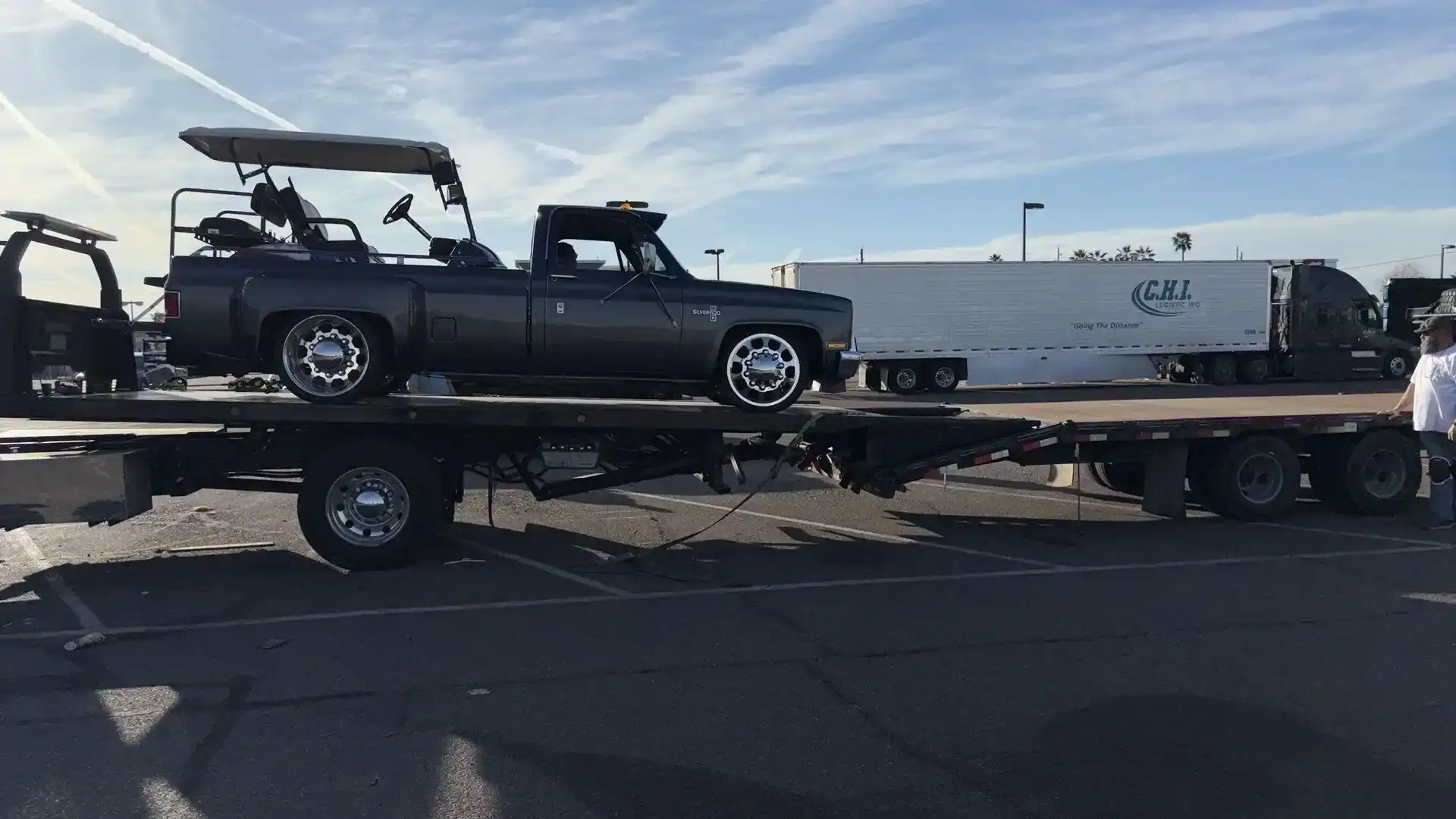 Freeway Towing & Storage loading a Chevrolet Silverado dually pickup onto a car-hauler trailer in Phoenix, AZ