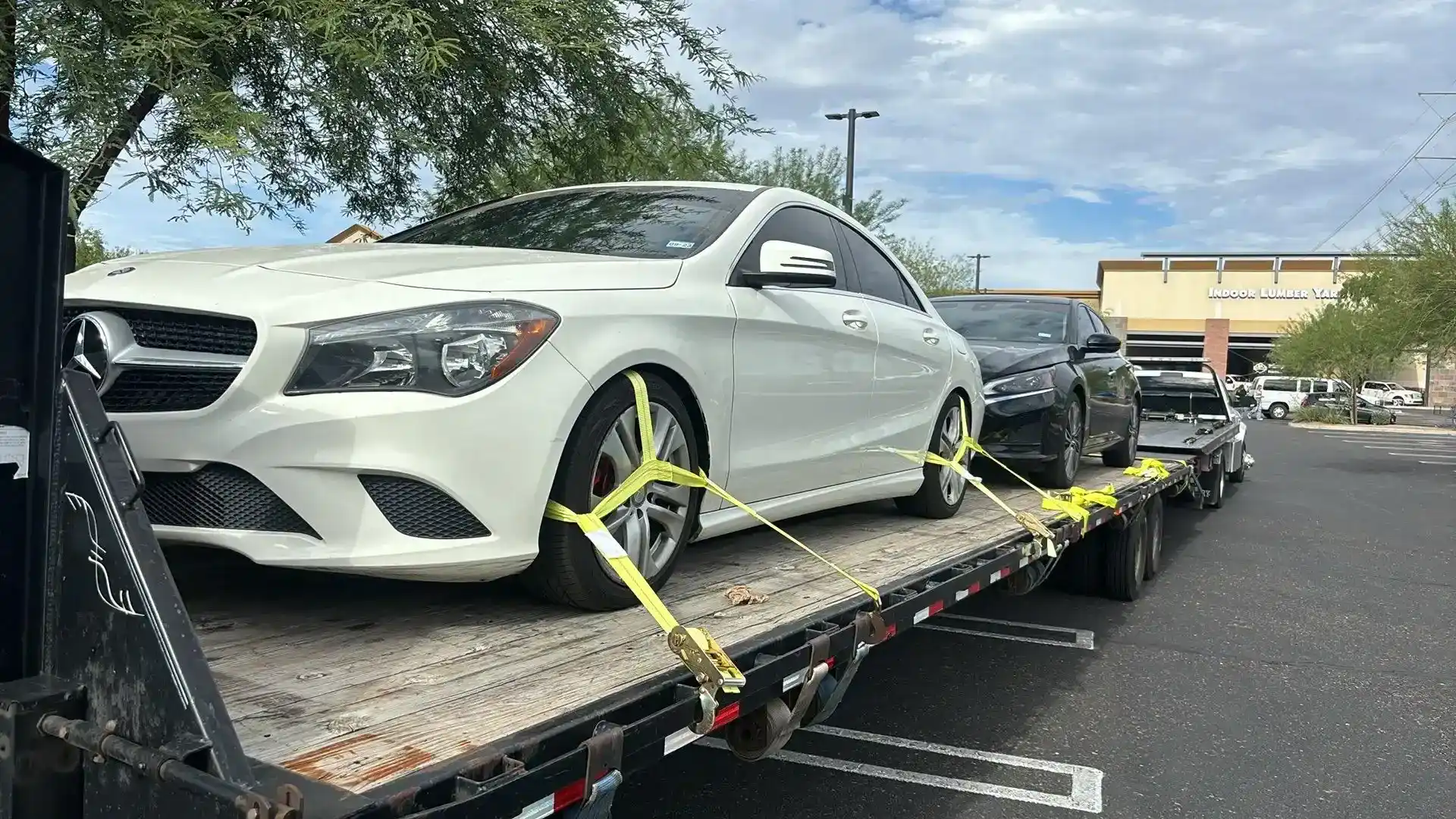 Freeway Towing & Storage decking a vehicle onto the upper deck of a multi-car transport trailer in Phoenix, AZ