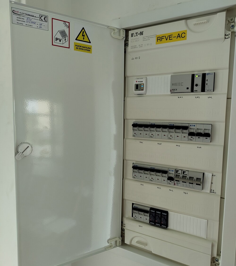Detailní pohled na úhledně zapojený AC rozvaděč fotovoltaické elektrárny s bezpečnostními prvky.