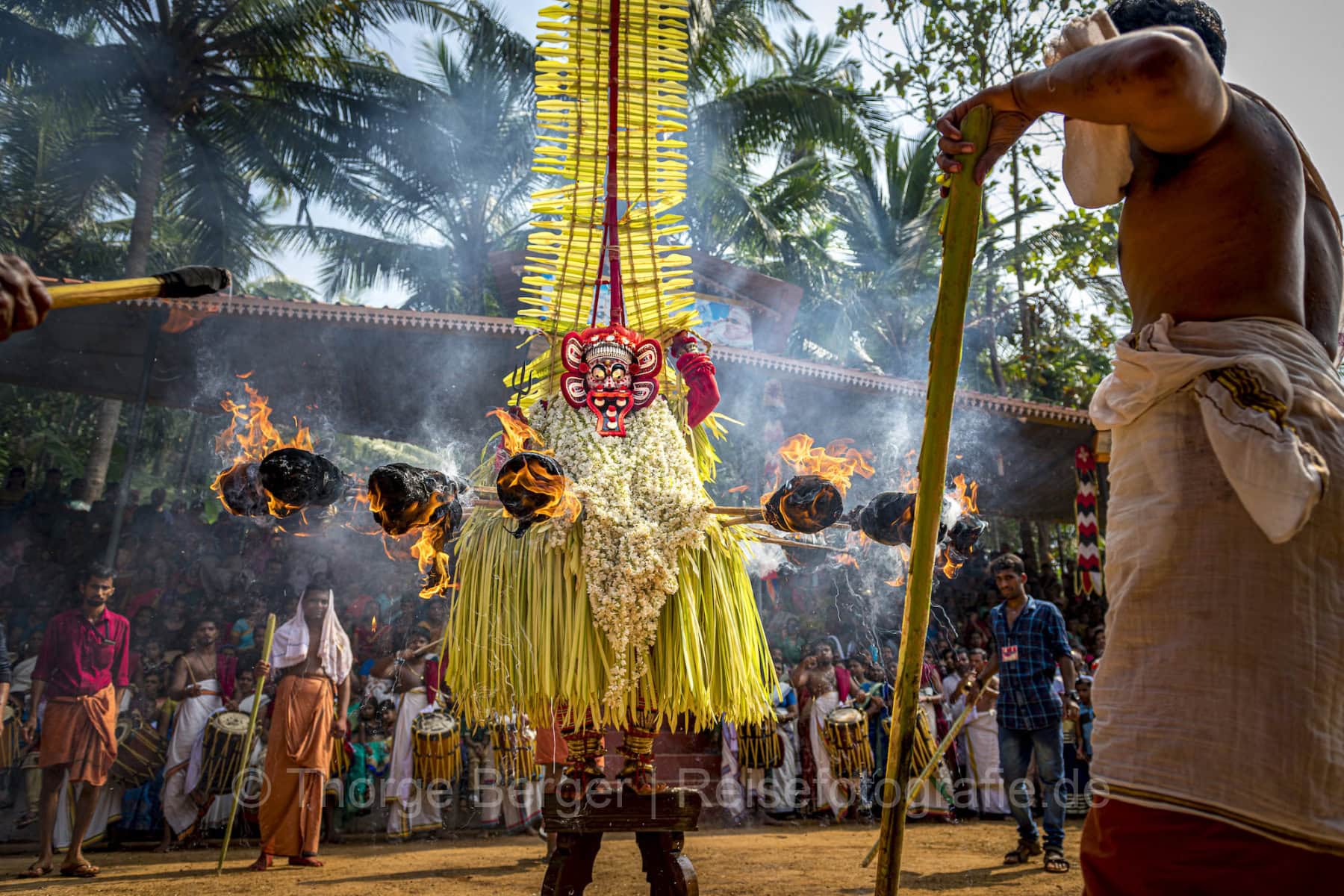 Theyyam-Gott mit Fackeln