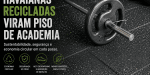 Barra de musculação sobre piso emborrachado sustentável produzido com resíduos reciclados das Havaianas em ambiente de academia.