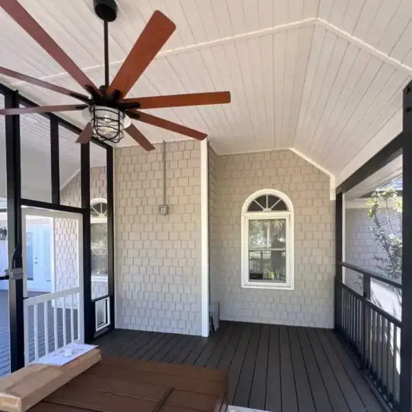 Inside a newly built outdoor living space in Wilmington NC featuring a custom deck and covered entertaining area by RGR Construction & Roofing.
