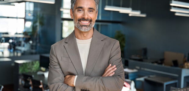 Smiling middle aged ceo business man looking at camera in office, portrait.