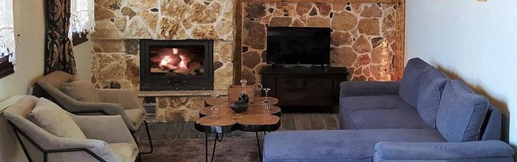 Cozy living room with fireplace and sofa in Apartment Smaro at Rustic House Embonas Rhodes