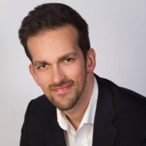 A professional advisor from Safe Pacific Financial, distinguished by short dark hair and a trimmed beard, wears a crisp white shirt and classic black blazer. He offers a confident smile while looking at the camera, set against a clean light background—reflecting expertise in wealth management, the infinite banking strategy, financial advice for affluent Canadian families, and tailored Canadian life insurance solutions.