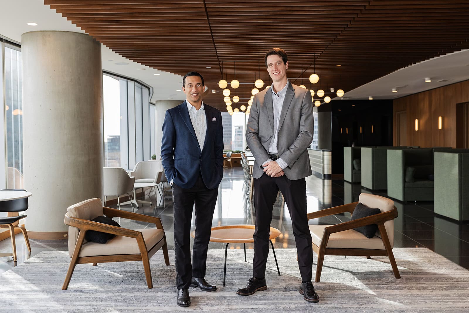 Two advisors from Safe Pacific Financial smile in a bright lounge, reflecting expertise in Canadian wealth management and infinite banking.