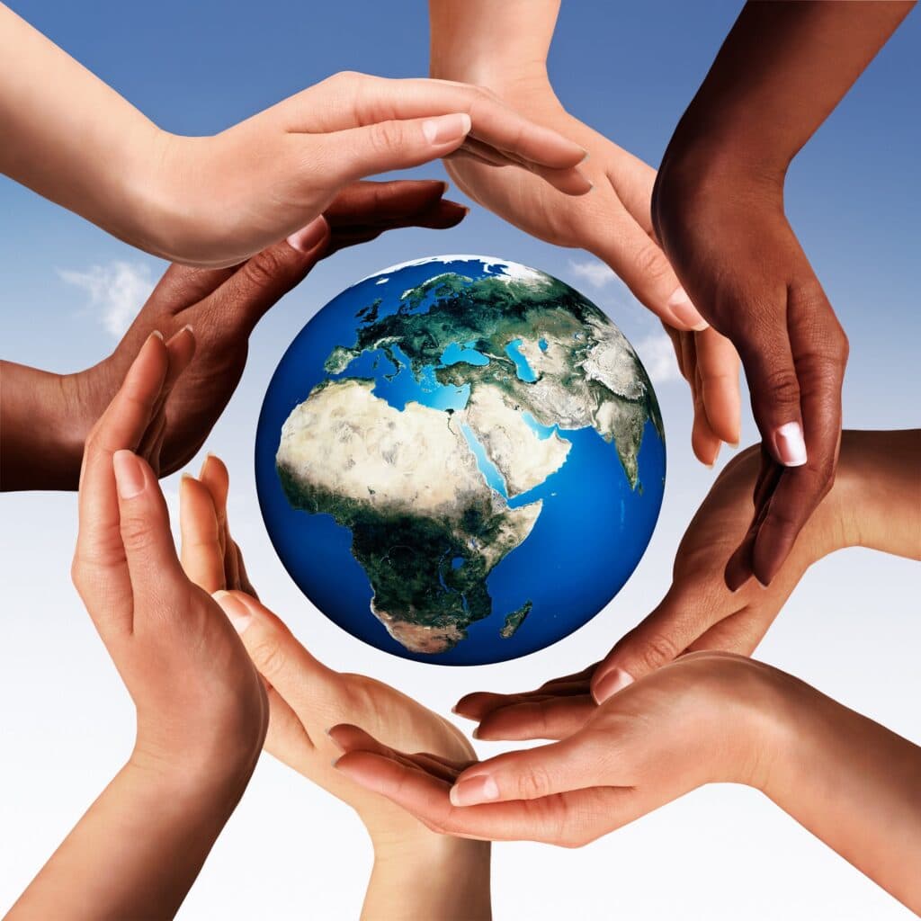 Conceptual peace and cultural diversity symbol of multiracial hands making a circle together around the world the Earth globe on blue sky background