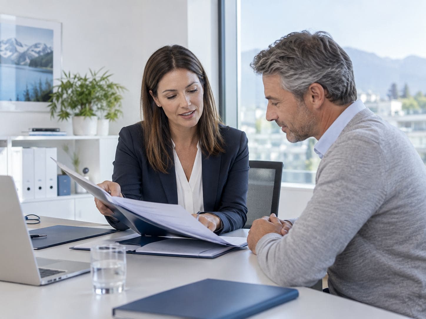 Conseiller en assurances examinant un dossier avec un client.