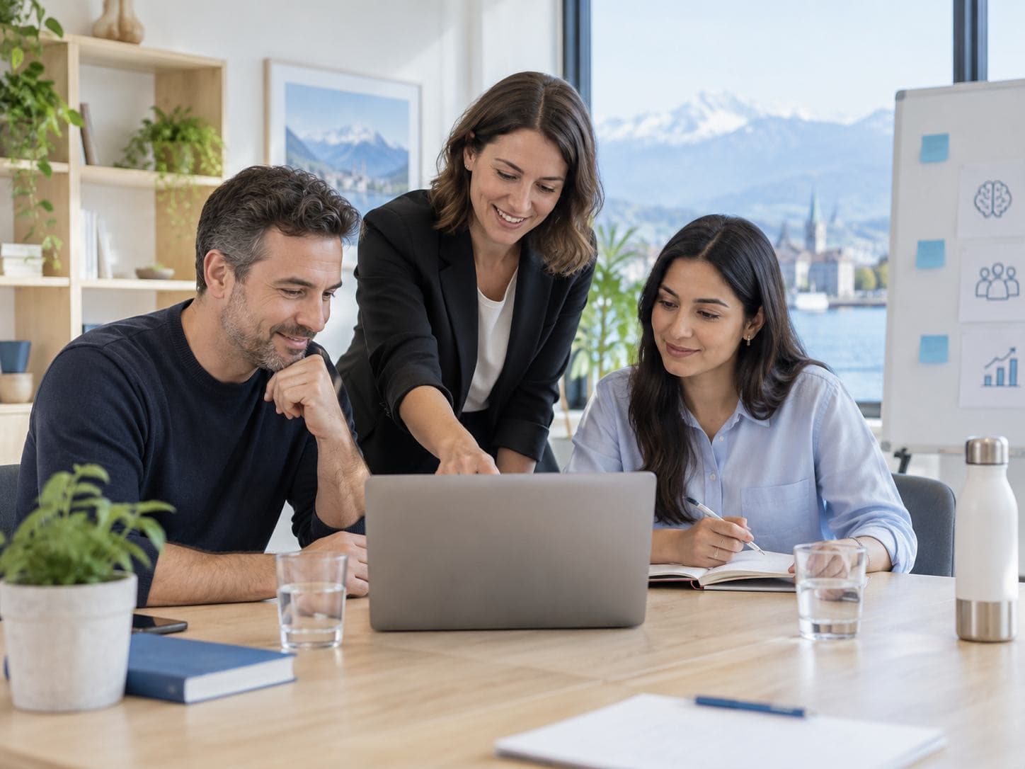 Formatrice accompagnant deux adultes dans un exercice sur ordinateur.