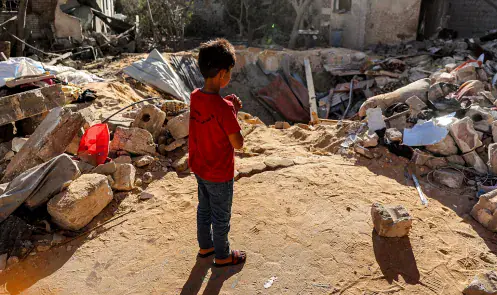 A boy stands before an impact crater at the site of a building that was hit by Israeli bombardment in Rafah in the southern Gaza Strip on May 8, 2024 amid the ongoing conflict in the Palestinian territory between Israel and the militant group Hamas.