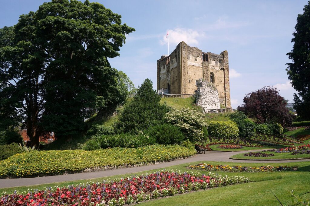 The Norman keep of Guildford Castle above the flower beds of the castle gardens