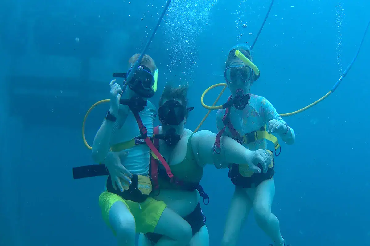 A calm guided SNUBA group underwater in clear Sint Maarten water
