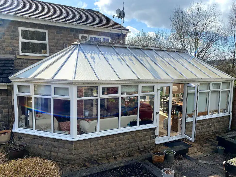 old brick conservatory with one of the white framed open door