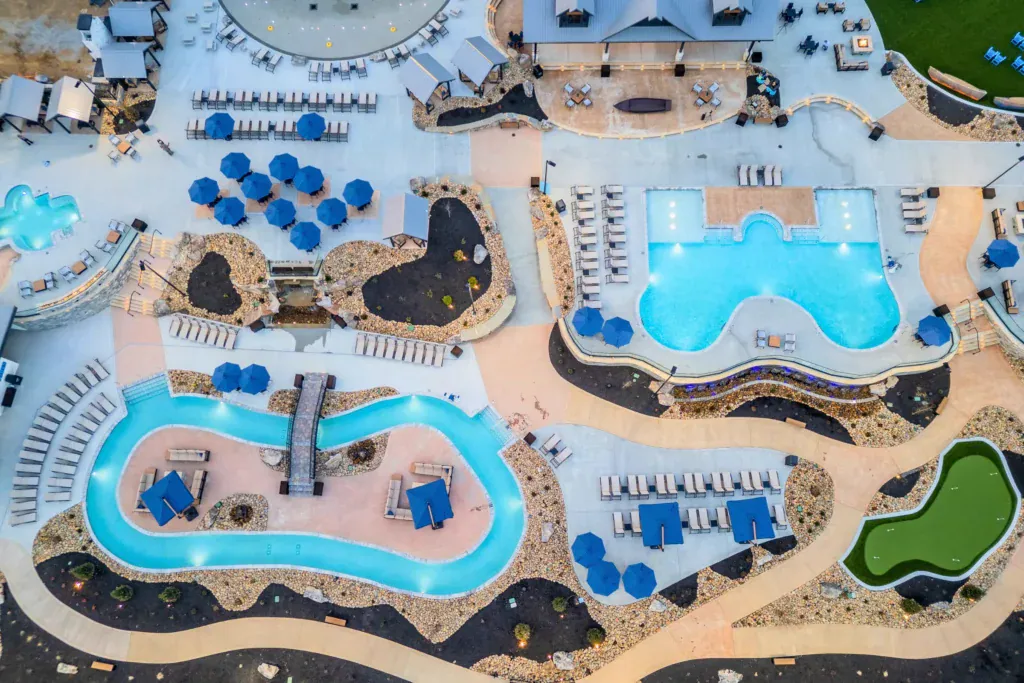 Aerial view of Rambling River Water Park featuring a lazy river, infinity pool, splash pad, and resort amenities.