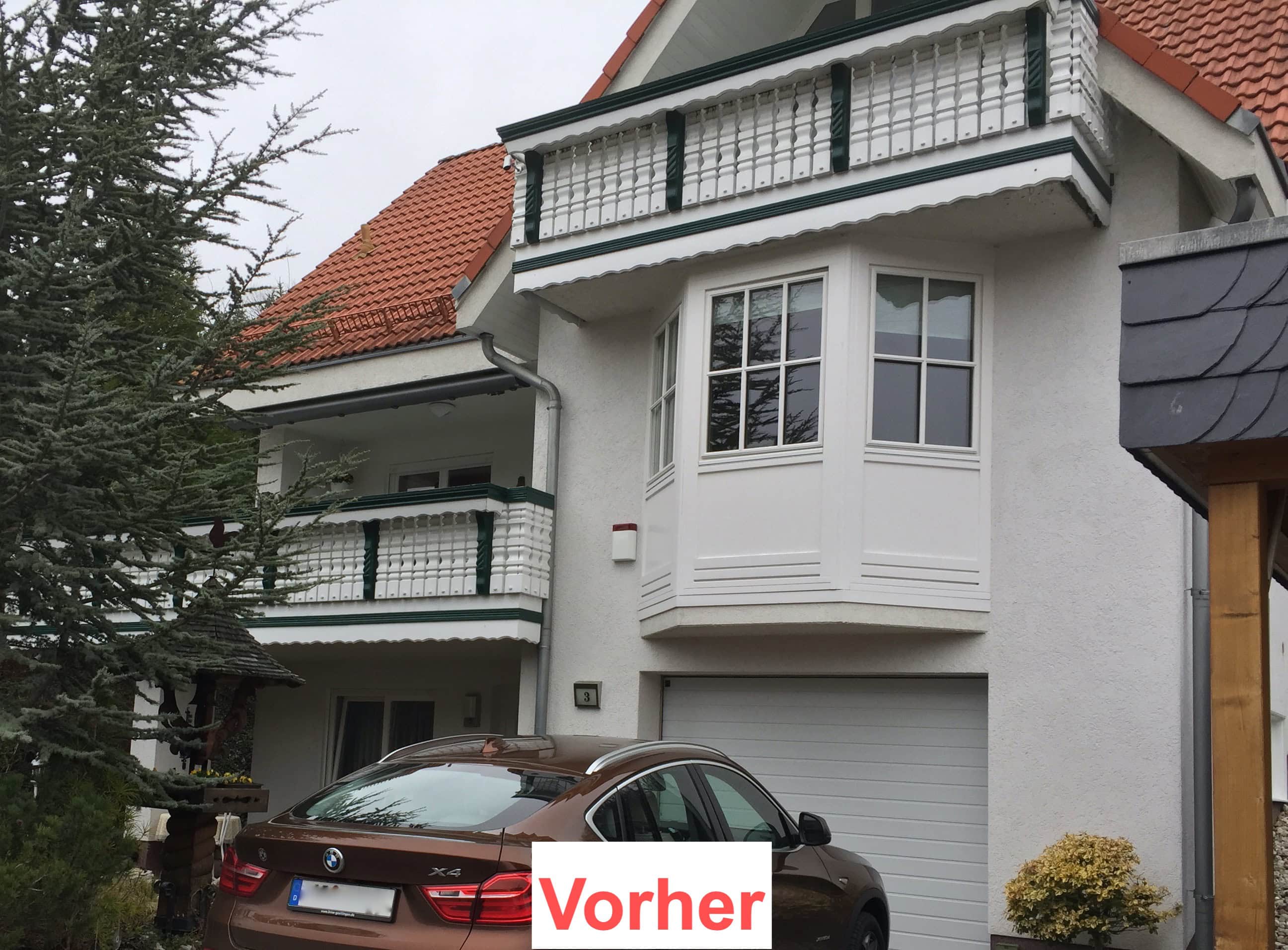 Vorher-Ansicht eines weißen Wohnhauses mit zwei Balkonen von Stahl- und Metallbau Drost. Die Balkone haben weiße Balustraden mit grünen Akzenten. Ein brauner BMW X4 ist vor der Garage geparkt.