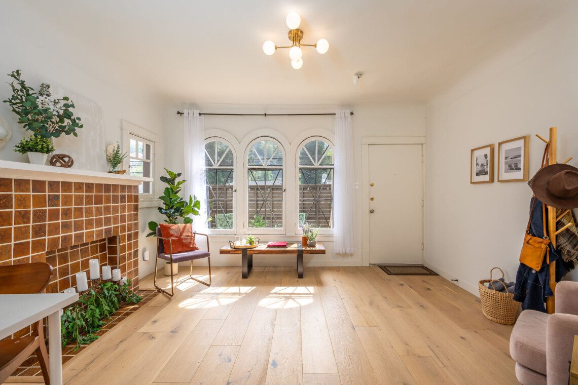 Sunlight pours through arched windows into this inviting living space, highlighting the home’s original charm and warm finishes. A peaceful spot to unwind, with a connection to the courtyard just beyond.