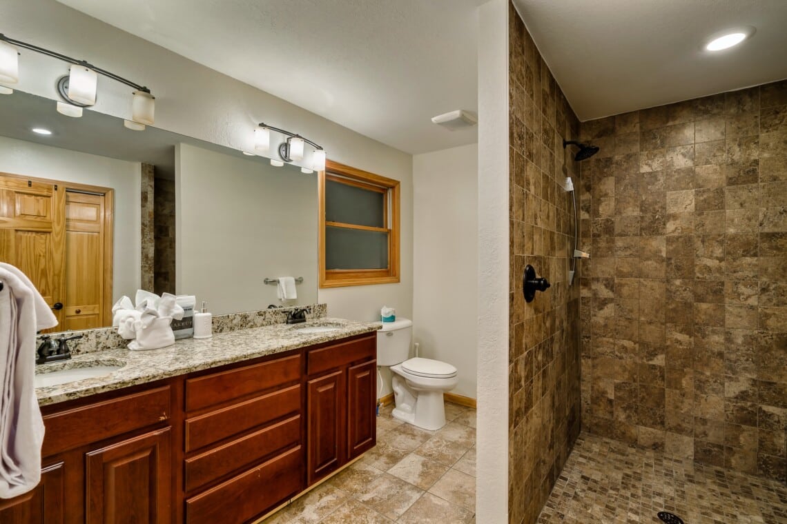Spacious ensuite bathroom with shower, including a built-in bench for added comfort.