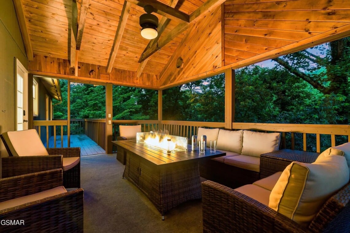 Secluded covered deck with a fire table; perfect for cozy evenings under the trees.