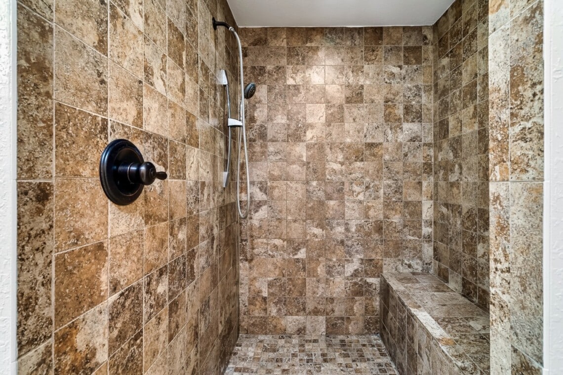 Lower-level bathroom with shower, including a convenient bench.