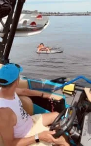 Guests on the SurfWhisperer boat watching a wakesurfer on the lake