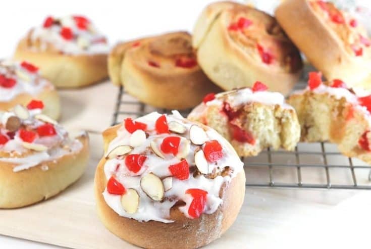 If you love eating baked goods for breakfast, try this Swedish Breakfast Rolls Recipe. These rolls are sweet, soft, fluffy, and perfect to eat for a quick grab and go breakfast. This easy Swedish breakfast bun recipe is consists of a sweet dough flavored with cardamon. Almonds and cherries are added and the sweet rolls are topped with a delicious icing glaze.