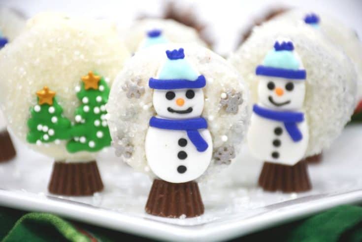 Prepare perfectly decorated Snowman Snow Globe Cookies for the holidays. These sweet, decorative holiday cookies are a must-have for children and adults. This easy cookie recipe is made with OREOS. These chocolate covered OREOS are a fun Christmas Cookie recipe to make and share.