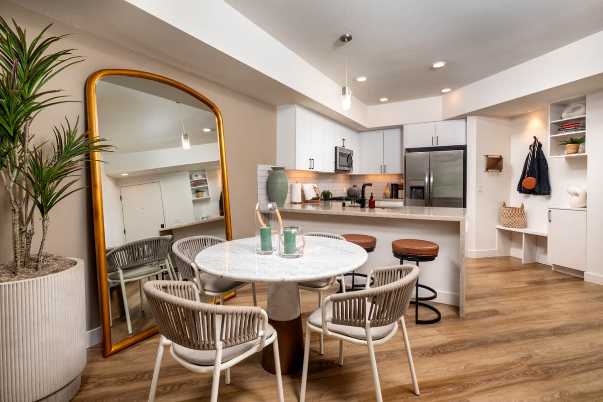 A kitchen and a dining area with a table and chairs at The Wyatt apartments for rent in San Diego.