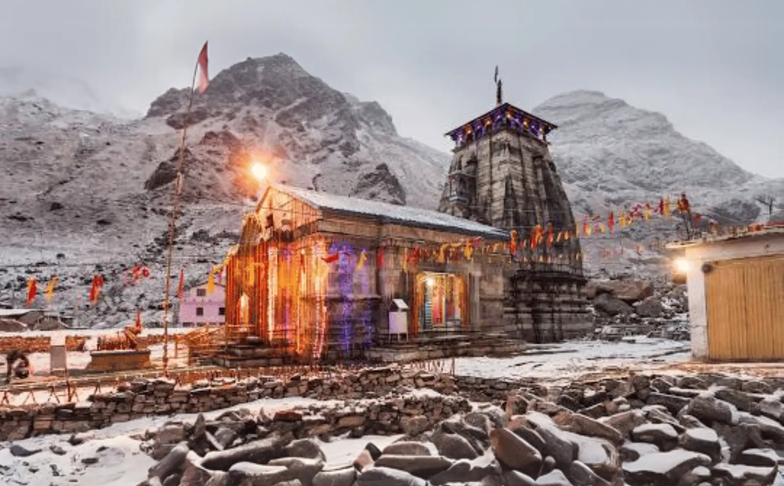 Kedarnath Dham pilgrimage site, surrounded by majestic snow-covered peaks.