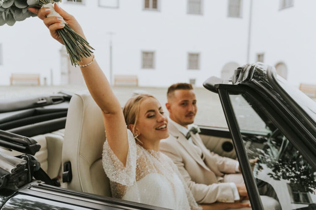 Hochzeitspaar im Oldtimer im Schlosshof Höchstädt