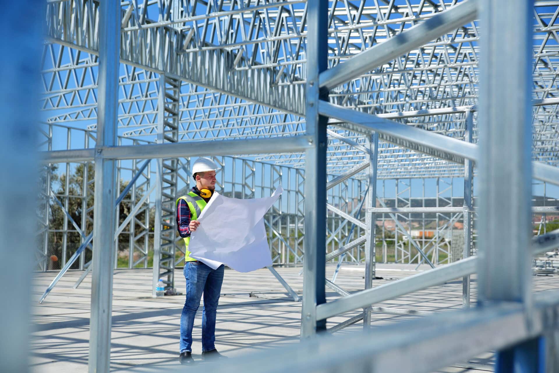 Engineer reviewing permit drawings at a steel building construction site