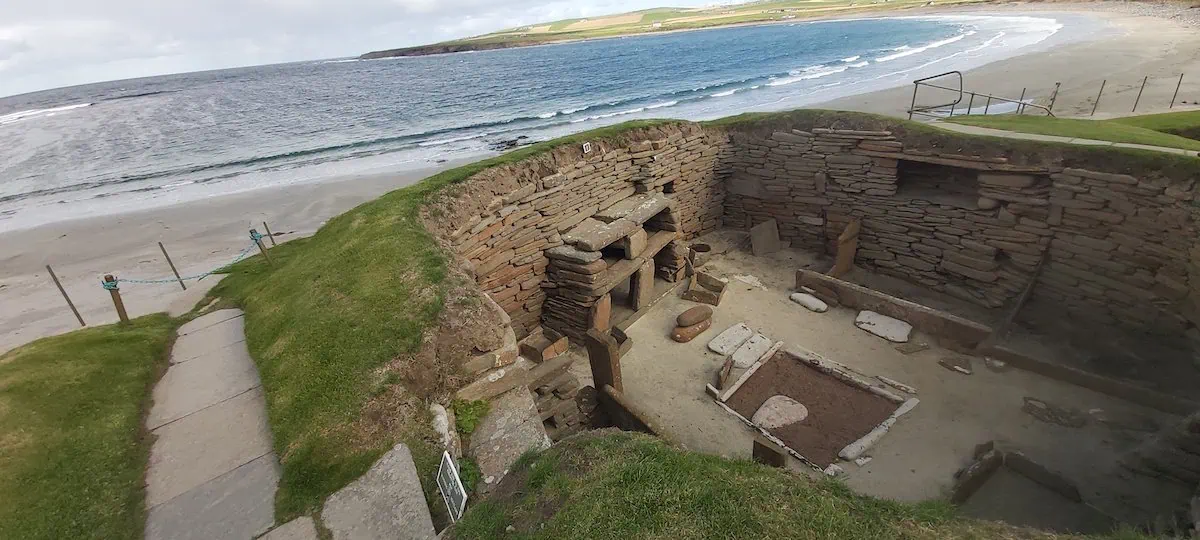 skara-brae-with-skail-bay-in-the background-in-the orkney-isles