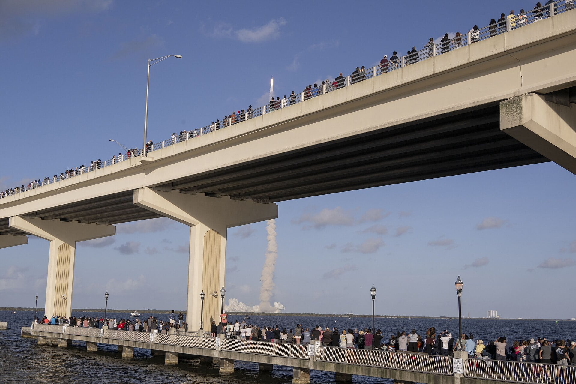 Crowds watching a rocket launch from Max Brewer Bridge in Titusville