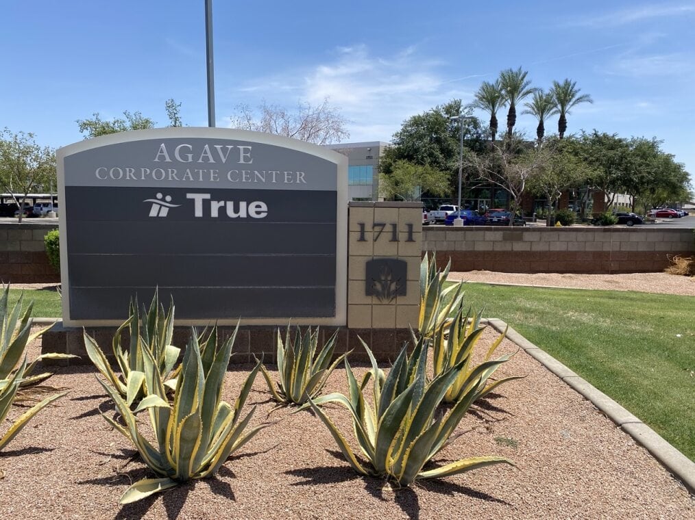 Sign for Agave Corporate Center with landscaping.