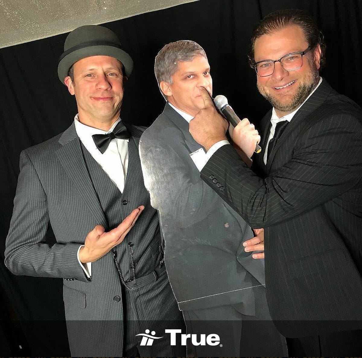 Two men posing with a cardboard cutout.