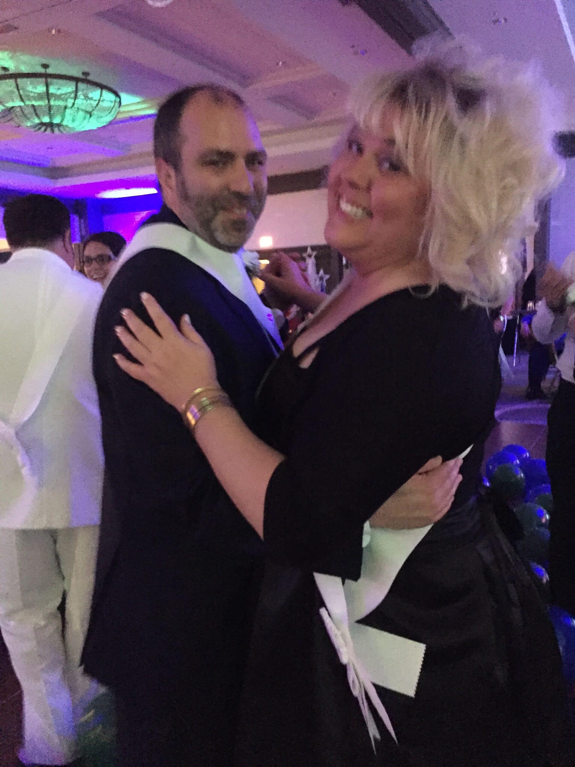 Couple dancing joyfully at a festive event.