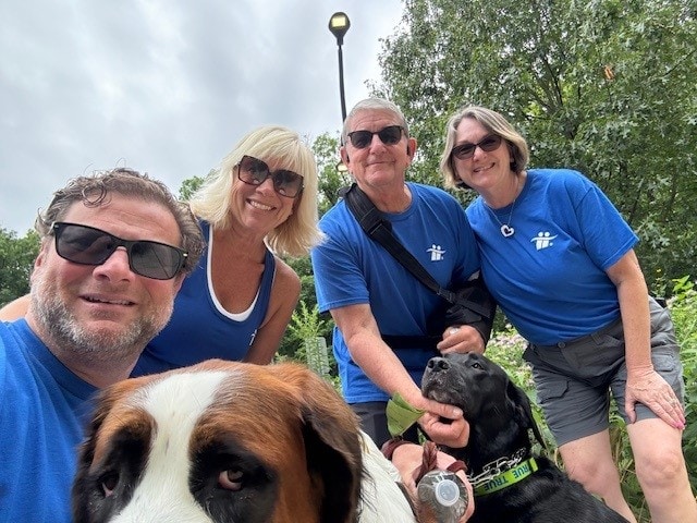 Group of friends posing with their dogs.