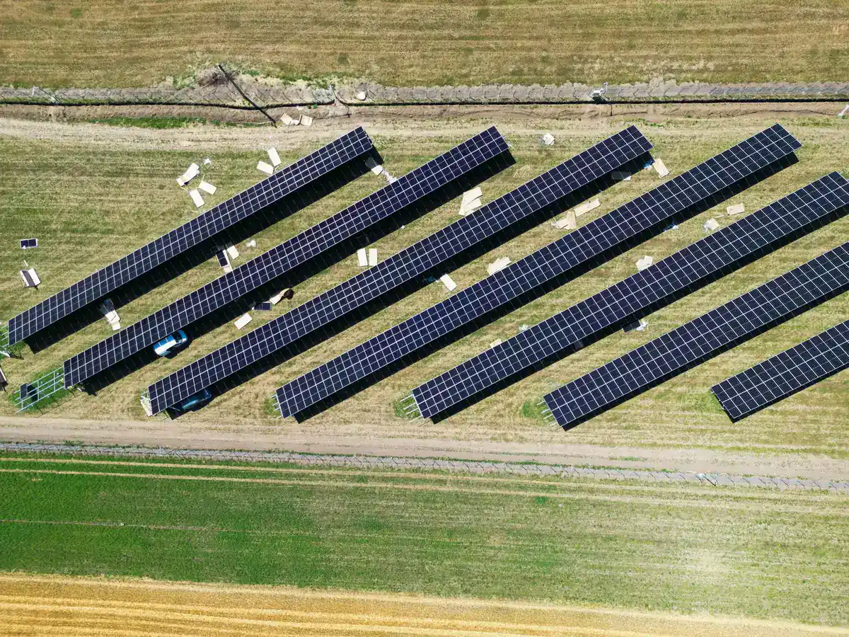 Rânduri de panouri fotovoltaice pe structuri fixe, văzute de sus