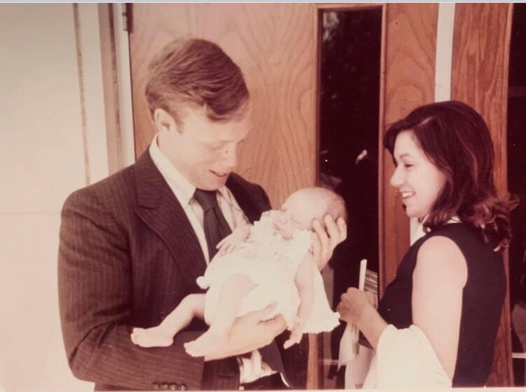 Christy's parents holding her sister Kathy at her baptism