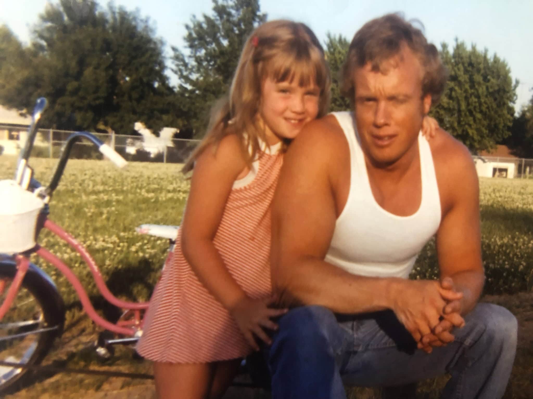 Young Christy leaning on her father's shoulder
