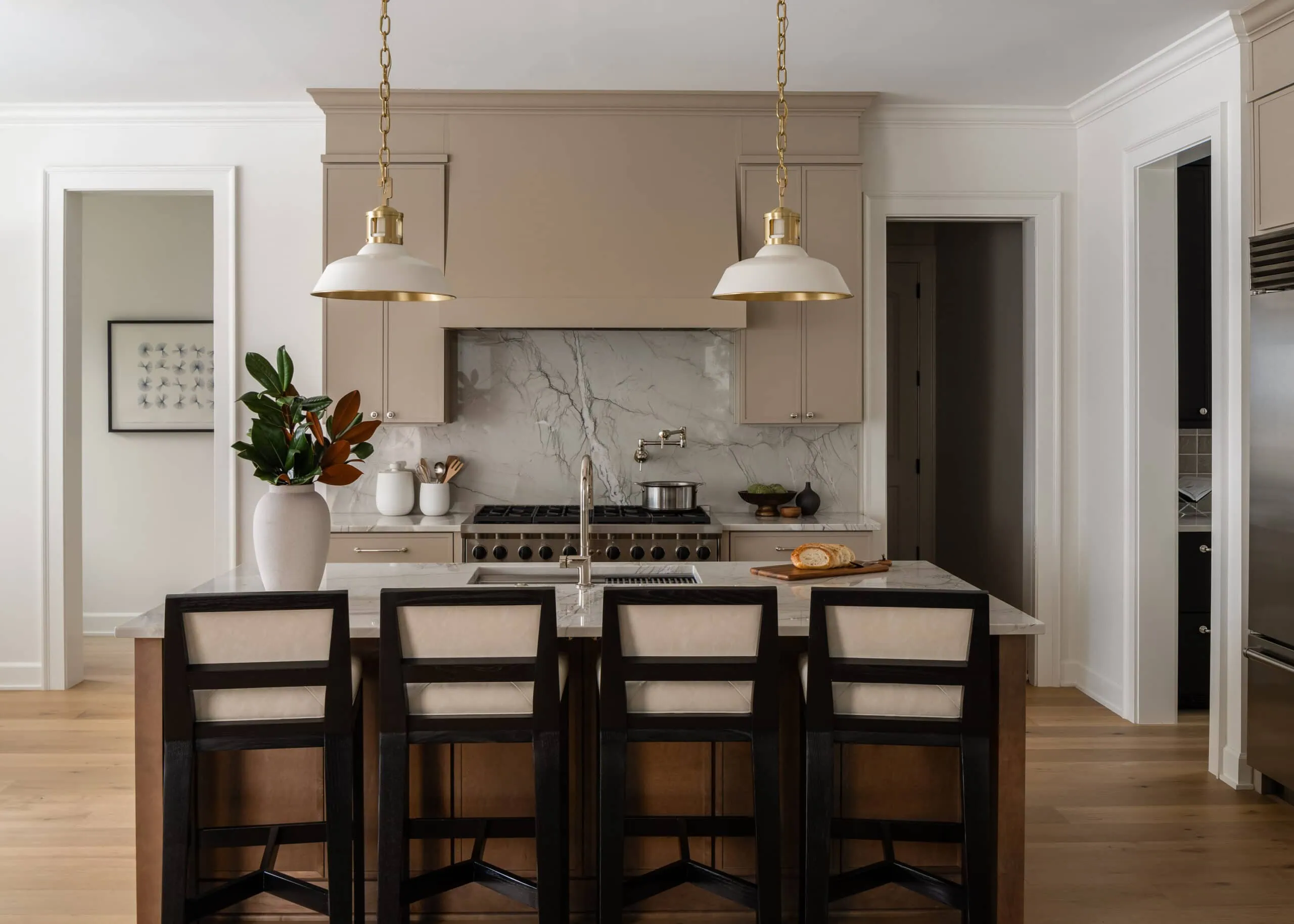 Light kitchen with a marble backsplash and woven counter stools