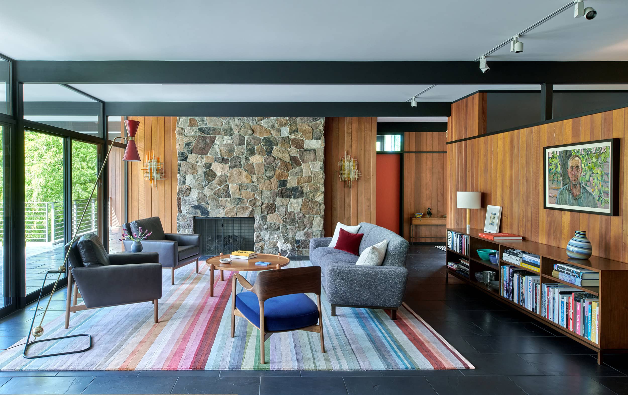 Mid-century living room with wood paneling and a stone fireplace