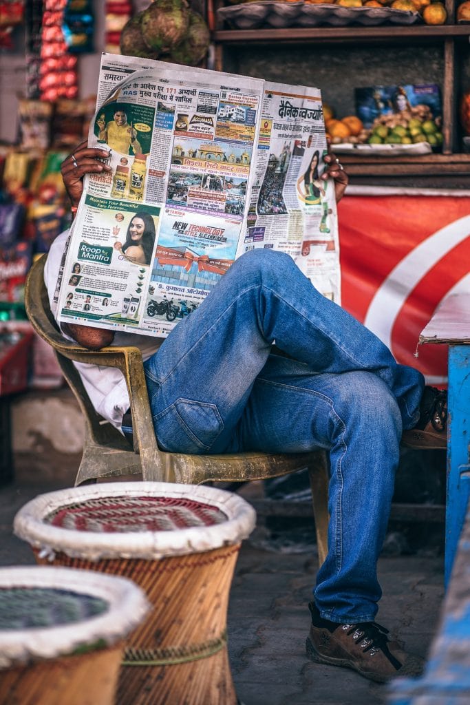 Journalist reading press release examples in a newspaper