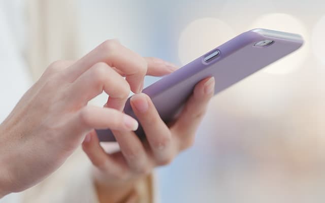 スマホを持つ手と操作しようとしている手