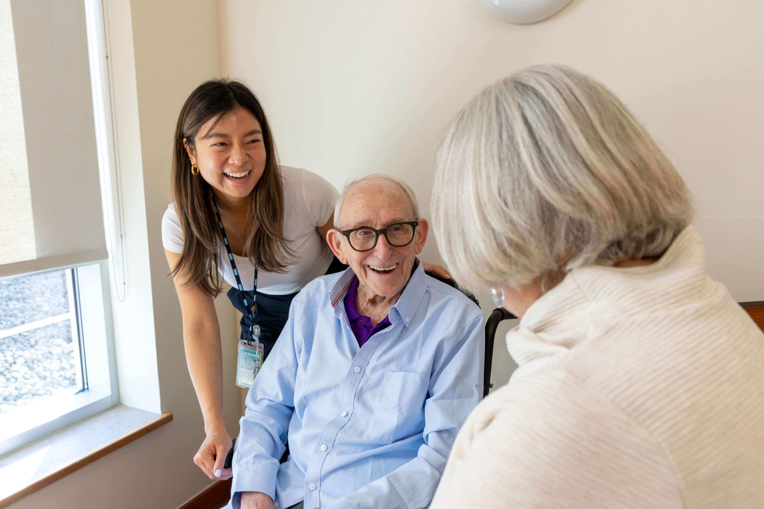Baycrest support having a conversation with a patient smiling and having a good time