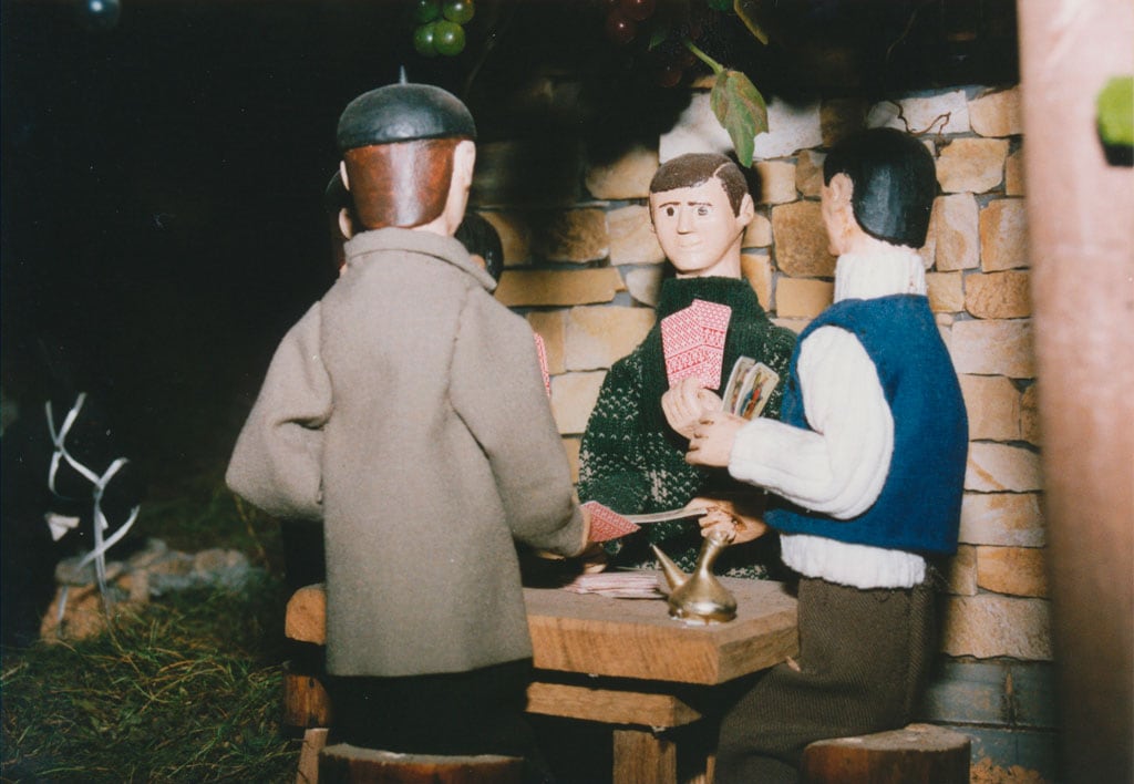 Hombres jugando a la brisca con el porrón en la mesa.