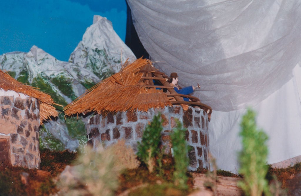 Un hombre acabando de construir la palloza.