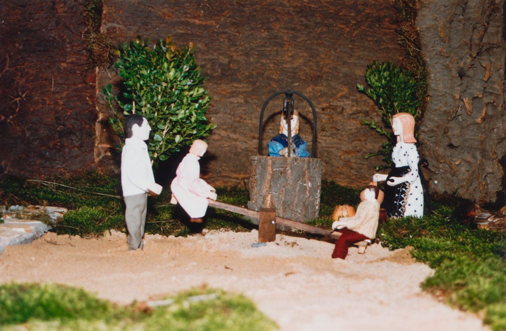 Niños columpiandose junto a la escuela.